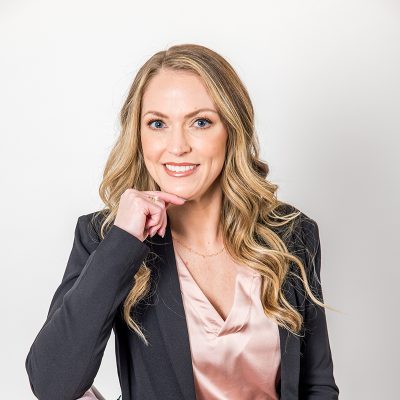 A Woman Wearing A Suit And Tie Smiling At The Camera