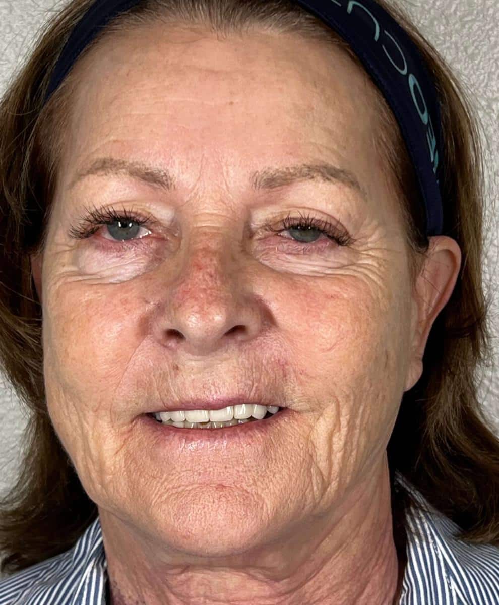 a close up of a man wearing glasses and smiling at the camera